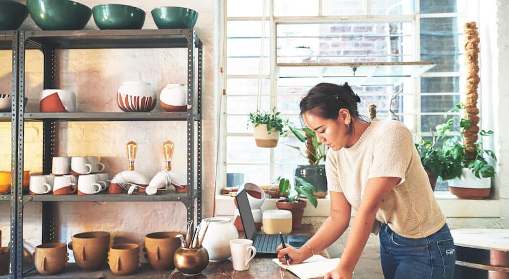 Pottery, owner and woman with writing in workshop for inventory management, order checklist and planning. Small business, artist and notebook for ceramics inspiration, creative ideas and information.